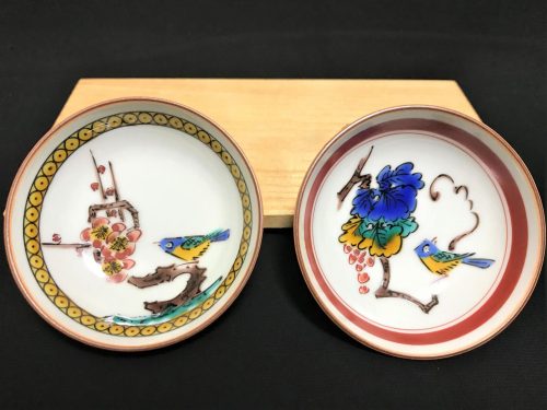 花や小鳥が色鮮やかに絵付けされた2枚の陶磁器(小皿)と付属品