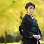 喪服着物（黒喪服）を着用し、数珠を持つ女性
