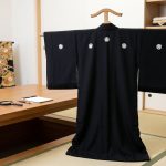 背中や両袖に家紋があしらわれた黒の喪服（着物）
