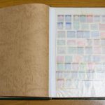 様々な記念切手がコレクションされた、歴史を感じさせる古い切手アルバムを開いた状態。