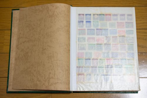 様々な記念切手がコレクションされた、歴史を感じさせる古い切手アルバムを開いた状態。